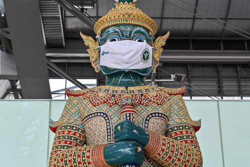 A statue wears a face mask at Suvarnabhumi Airport in Bangkok, as a reminder to travellers to help prevent the spread of Covid-19. Photo by Romeo Gacad  /  AFP