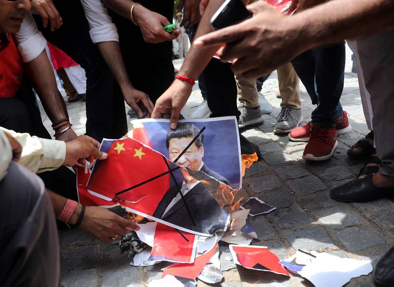 Right-wing Hindu activists angry at China for stopping Indian pilgrims from crossing the border burn posters portraying Chinese president Xi Jinping and the Chinese national flag during a protest in New Delhi on July 4, 2017. Rajat Gupta / EPA