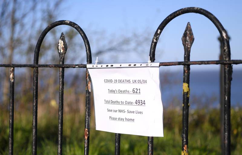 A sign on a fence on a popular costal walk, tells people to stay at home as it gives the number of deaths to date on April 06, 2020 in Penarth, Wales. Getty Images