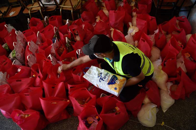 An Algerian volunteer, part of the charitable association "Joy of Eid", fills food parcels to be distributed to needy families ahead of Eid Al Fitr.  AFP