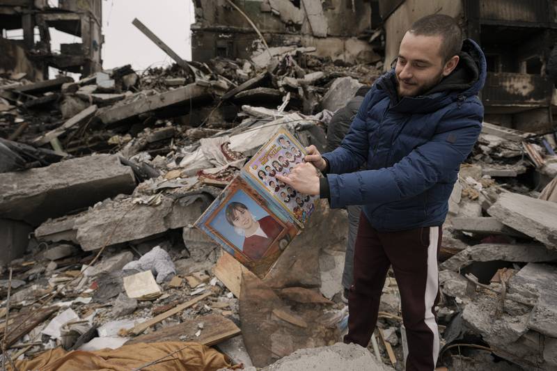 Dmitriy Evtushkov, 25, points to his picture in a primary school album retrieved from the rubble of a block of flats. AP
