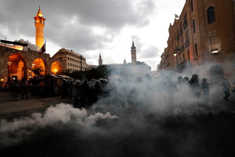 Riot police advance to push back anti-government protesters during demonstrations following Tuesday's massive explosion which devastated Beirut, Lebanon, Monday, Aug. 10, 2020. Popular anger has swelled over corruption, mismanagement and political uncertainty. (AP Photo/Hassan Ammar)