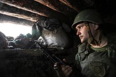 A DPR militia member monitors a section of the road near Avdiivka. EPA