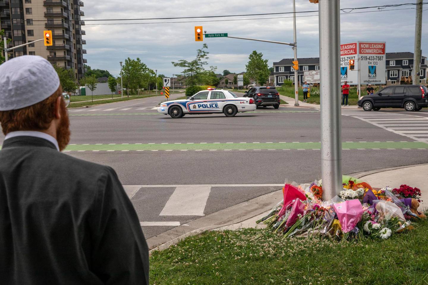 A police car passes the location where a family of five was hit by a driver, in London, Ontario, Monday, June 7, 2021. Four of the members of the family died and one is in critical condition. A 20-year-old male has been charged with four counts of first degree murder and count of attempted murder in connection with the crime. (Brett Gundlock/The Canadian Press via AP)