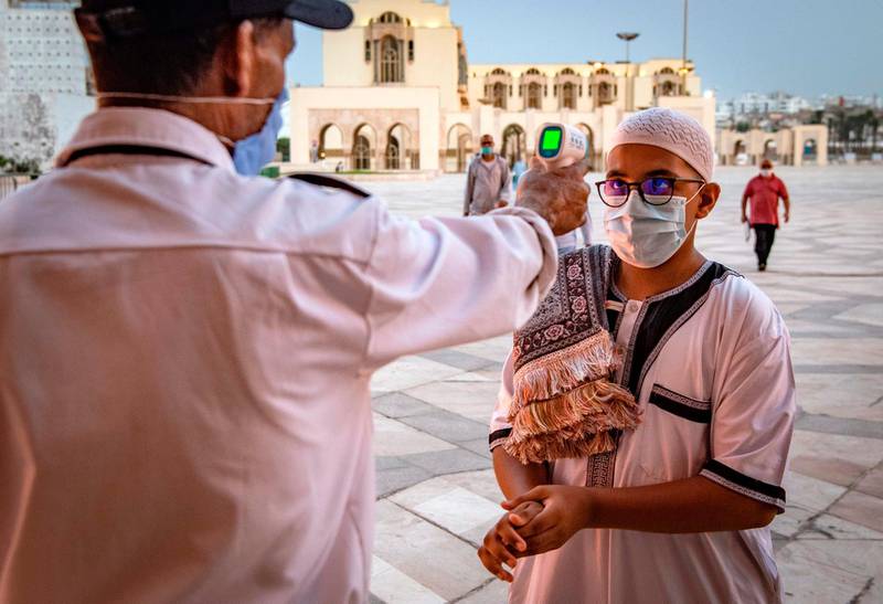 A mask-clad worker measures the body temperature of a worshipper arriving for prayers at the Hasan II mosque, one of the largest in Africa, in Morocco's Casablanca. AFP