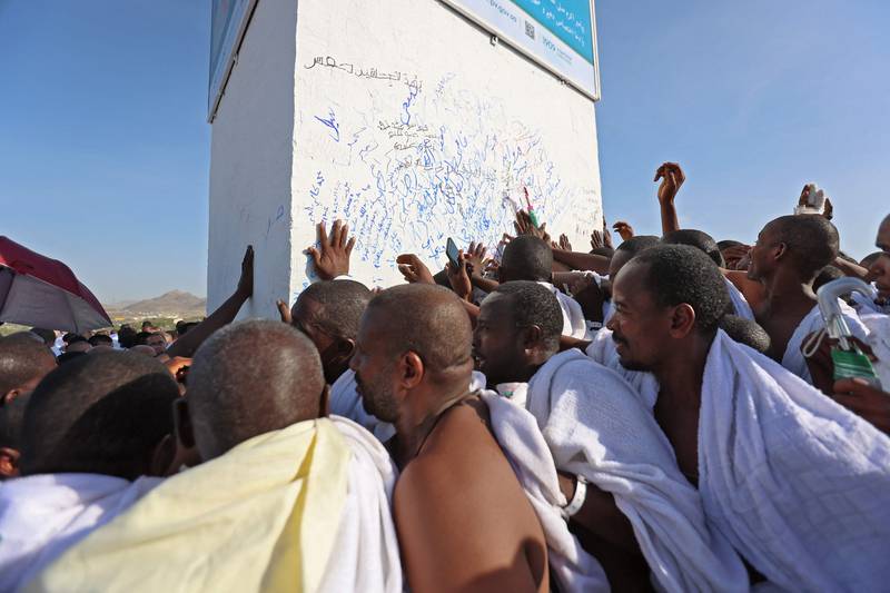 People touch the pillar at the top of Mt Arafat, on Friday, during Hajj.  AFP