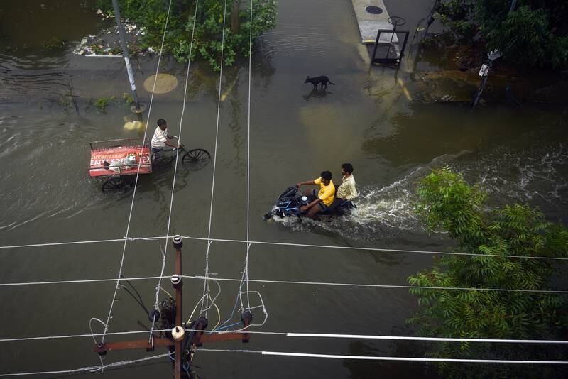 People cross a flooded intersection after heavy rain in Chennai, India. EPA