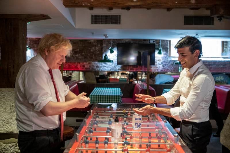 British Prime Minister Boris Johnson and Rishi Sunak use hand sanitiser during a visit to Pizza Pilgrims in West India Quay, London Docklands, as lockdown rules eased in June 2020. Getty Images