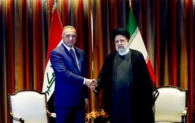 Mr Al Kadhimi greets Iran's President Ebrahim Raisi. 