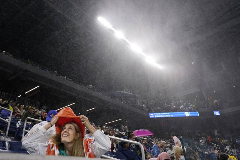 A fan takes cover from the rain in the Louis Armstrong Stadium during a match between Kevin Anderson of South Africa and Diego Schwartzman of Argentina. AP Photo