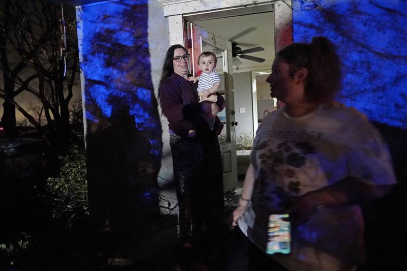 Annelise Cassar holds her nephew Eliam Cruice, 9 months, amid damage from the tornado.  AP Photo