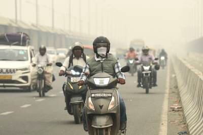 Traffic moves on a road enveloped by fog and smog in New Delhi, India. AP