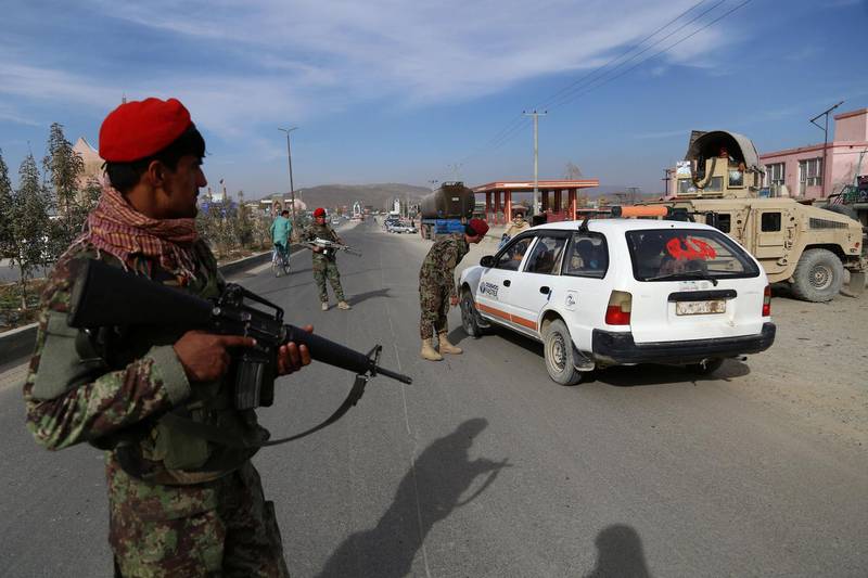 In this photo taken on October 29, 2018, Afghan security personnel search passengers in a checkpoint on Highway One in Ghazni. On a good day, it takes Mohammad less than three hours to drive from Ghazni to Kabul. But preparations for the hair-raising journey through Taliban-infested areas can take weeks. - TO GO WITH: Afghanistan-unrest-security, FEATURE by Allison JACKSON
 / AFP / ZAKERIA HASHIMI / TO GO WITH: Afghanistan-unrest-security, FEATURE by Allison JACKSON
