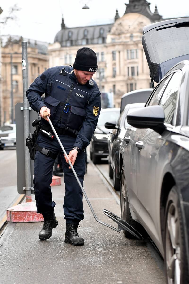 A police officer uses a mirror to check a car's undercarriage near the Bayerischer Hof hotel. EPA