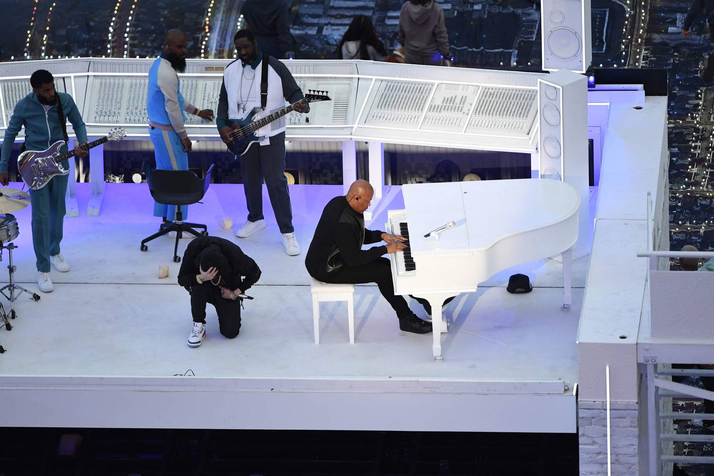 Eminem kneels on stage as he performs with US rapper Dr Dre during the half-time show. AFP