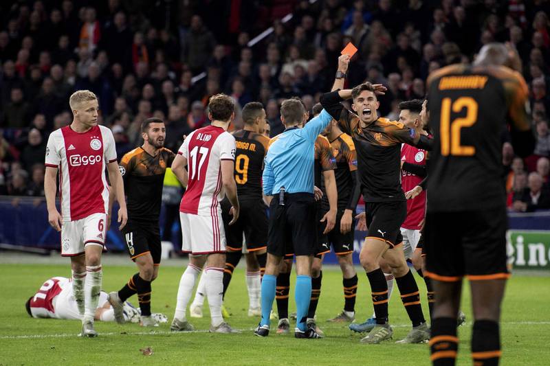 Dusan Tadic of Ajax lies on the floor as Valencia defender Gabriel Paulista receives a red card. EPA