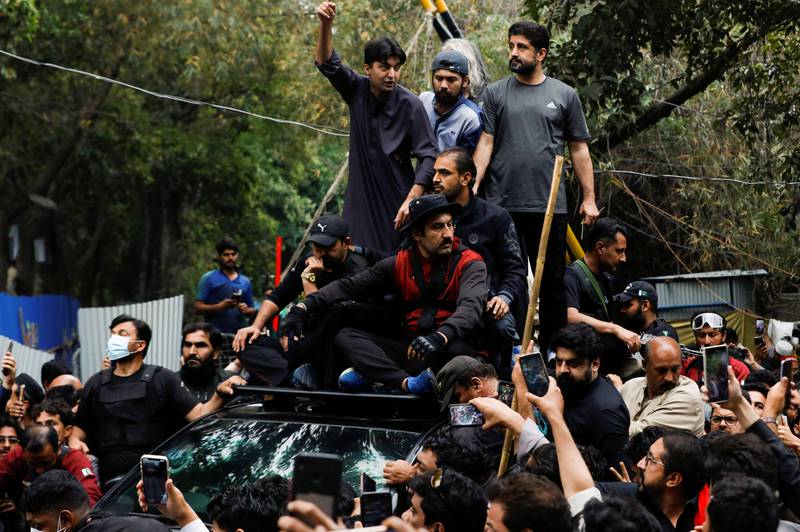 Supporters of former Pakistani prime minister Imran Khan escort vehicles as Mr Khan leaves to appear before the Lahore High Court. March 17, 2023.  Reuters