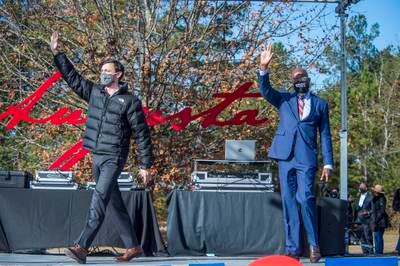 Jon Ossoff, left, and Raphael Warnock waves to the crowd during a campaign rally in Augusta, Ga., Monday, Jan. 4, 2021. Democrats Ossoff and Warnock are challenging incumbent Republican Senators David Perdue and Kelly Loeffler in a runoff election on Jan. 5. (Michael Holahan/The Augusta Chronicle via AP)