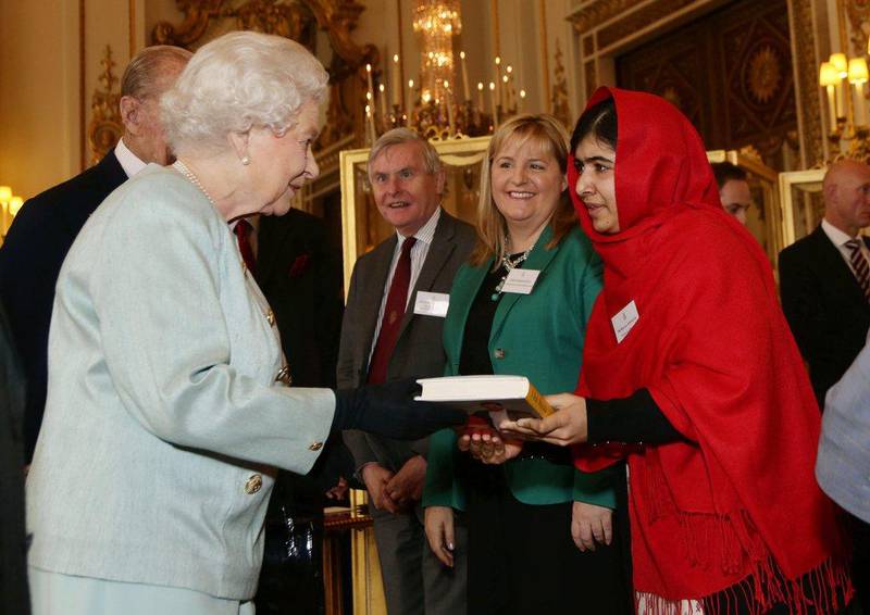 Malala Yousafzai gives a copy of her book, I Am Malala, to Britain’s Queen Elizabeth II during a reception at Buckingham Palace on October 18, 2013. Yui Mok / AP Photo