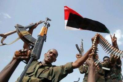 Sudanese armed forces raise their weapons during a visit by President Omar Al Bashir in Heglig on Monday.