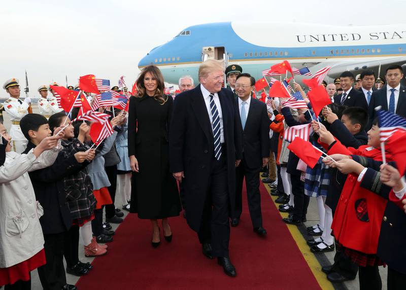 Children wave US and Chinese flags as US president Donald Trump and first lady Melania Trump arrive at Beijing Airport. Pang Xinglei / Xinhua via AP