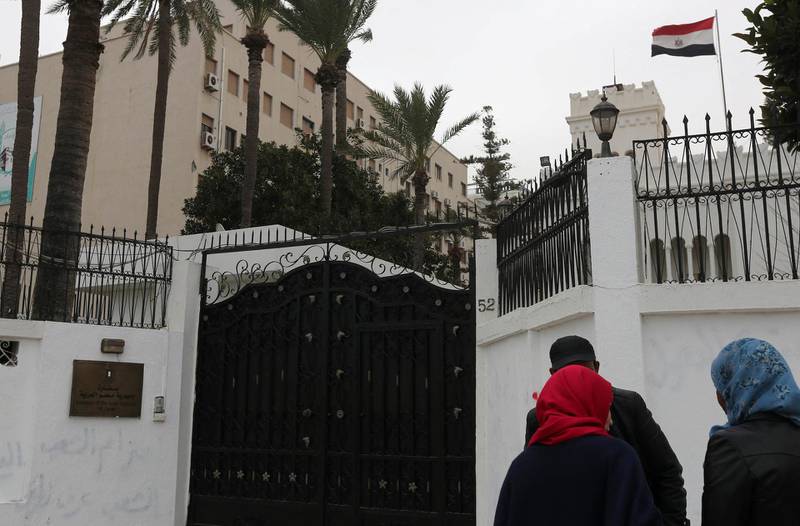Women talk with policemen on January 25, 2014 in front of the Egyptian embassy, where Egypt's cultural attache and three other embassy staff were seized by kidnappers in Tripoli, Libya. The early morning abduction came a day after the seizure of an embassy administrative adviser from his home in the capital and despite Libya's announcement of "reinforced security measures" around the Egyptian embassy.  AFP PHOTO MAHMUD TURKIA (Photo by MAHMUD TURKIA / AFP)