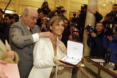 Former Spice Girl Victoria Beckham and Mohamed Al Fayed show off the most expensive item in the Harrods winter sale in 2002.