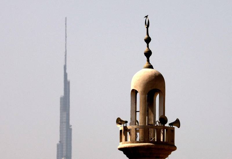 A mosque's minaret is pictured with the world's tallest tower – the Burj Khalifa – in the background as Ramadan gets under way in the UAE from Tuesday. AFP