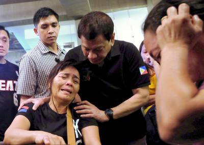 A handout photo made available by the Presidential Photographers Division shows Philippine president Rodrigo Duterte (C) comforting a relative of a victim that was killed in a blaze at shopping mall in Davao City. EPA