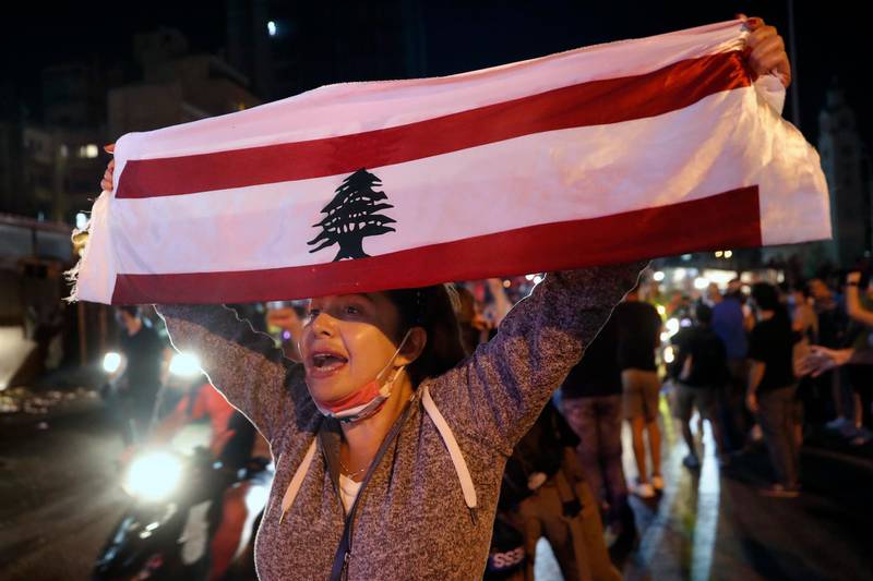 An anti-government protester chants slogans as she holds up a Lebanese flag in Beirut. AP Photo