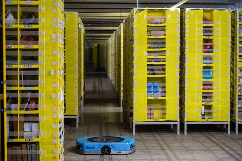A robot retrieves a pallet of items for employees to sort at an Amazon warehouse. The e-commerce company plans to cut about 10,000 jobs and the lay-offs have started, chief executive Andy Jassy said. Bloomberg