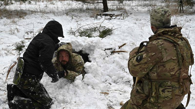 Ukrainian civilians build a shelter in the deep snow as part of a crash course in survival techniques near Kiev. AFP 