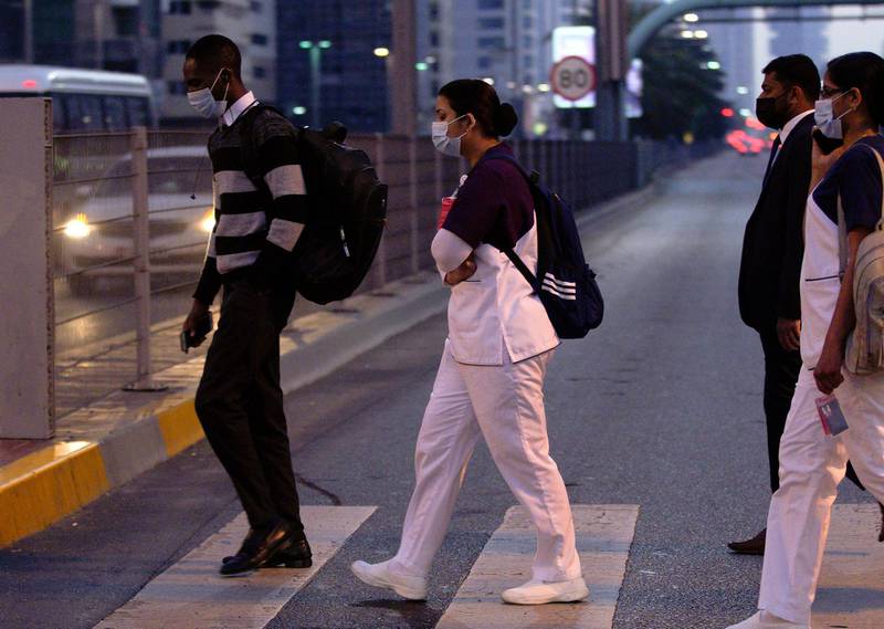 Abu Dhabi, United Arab Emirates, January 20, 2021.  Healthcare workers cross the street on another cold morning at central Abu Dhabi.Victor Besa/The National Section:  NA/Weather