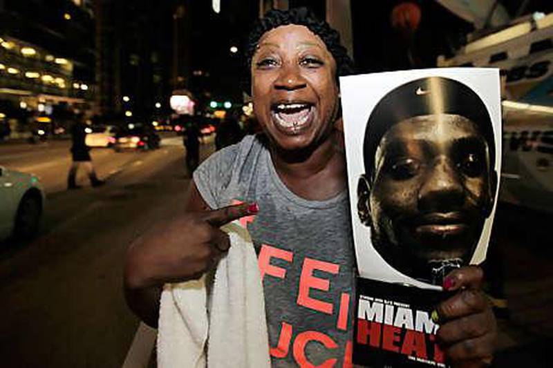 Rosalind Matthews, a Miami fan, holds a sign supporting LeBron James outside the arena where the Heat play.