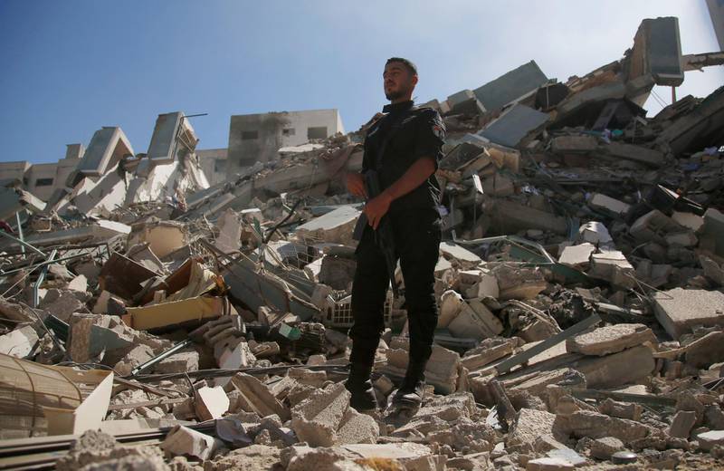A policeman stands on rubble from a building that housed the office of the Associated Press and other media organisations in Gaza City, which was destroyed by Israeli air strikes. AP