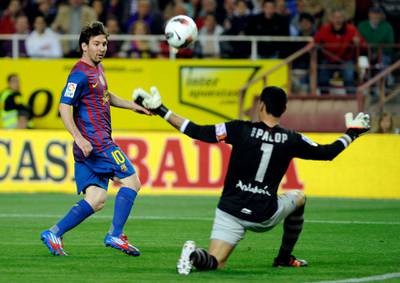 Barcelona's Argentinian forward Lionel Messi (L) scores against Sevilla's goalkeeper Andres Palop (R) during the Spanish League football match Sevilla vs FC Barcelona on March 17, 2012 at Ramon Sanchez Pizjuan stadium in Sevilla.   AFP PHOTO / CRISTINA QUICLER (Photo by CRISTINA QUICLER / AFP)