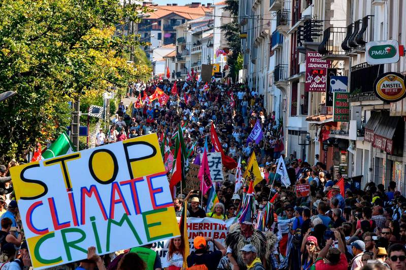 A placard reading 'stop climate crime' is seen as demonstrators take part in a march in Hendaye, south-west France to protest against the annual G7 Summit. AFP