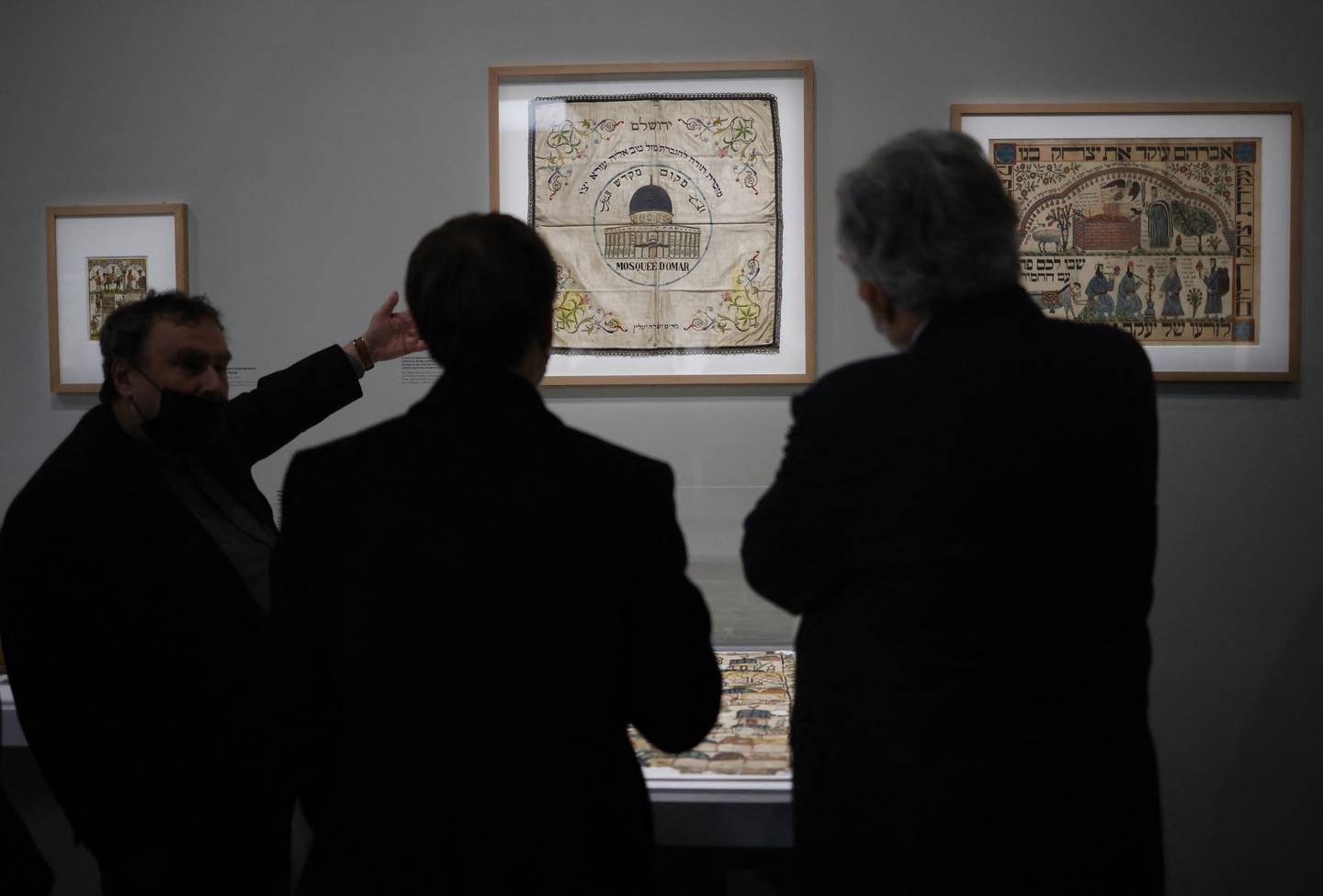 French President Emmanuel Macron, back, and French historian Benjamin Stora, left, visit the exhibition. AFP