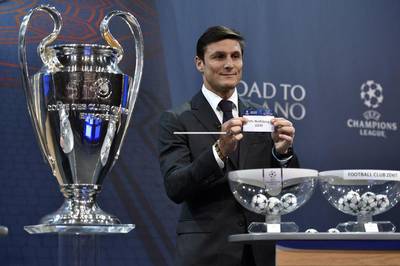 Uefa Champions League final ambassador Javier Zanetti shows the name of Wolfsburg during the draw for the last-16. Faabrice Coffrini / AFP