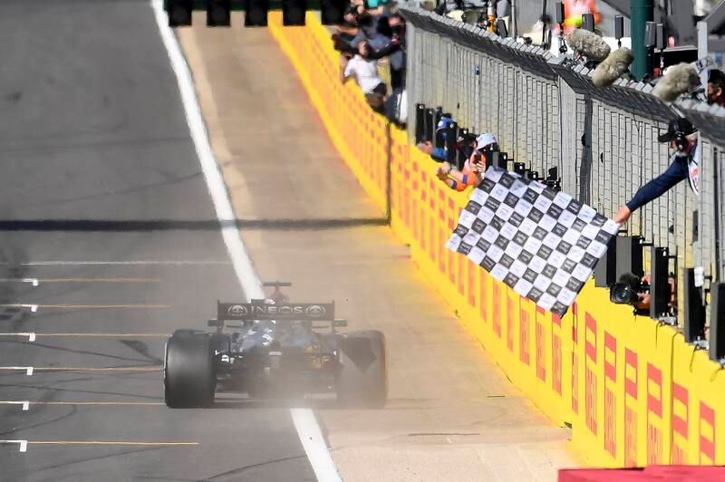 Lewis Hamilton takes the chequered flag at Silverstone.