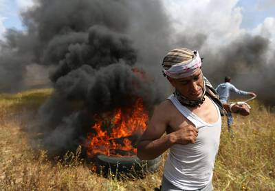 A Palestinian runs during clashes with Israeli troops. Ibraheem Abu Mustafa / Reuters