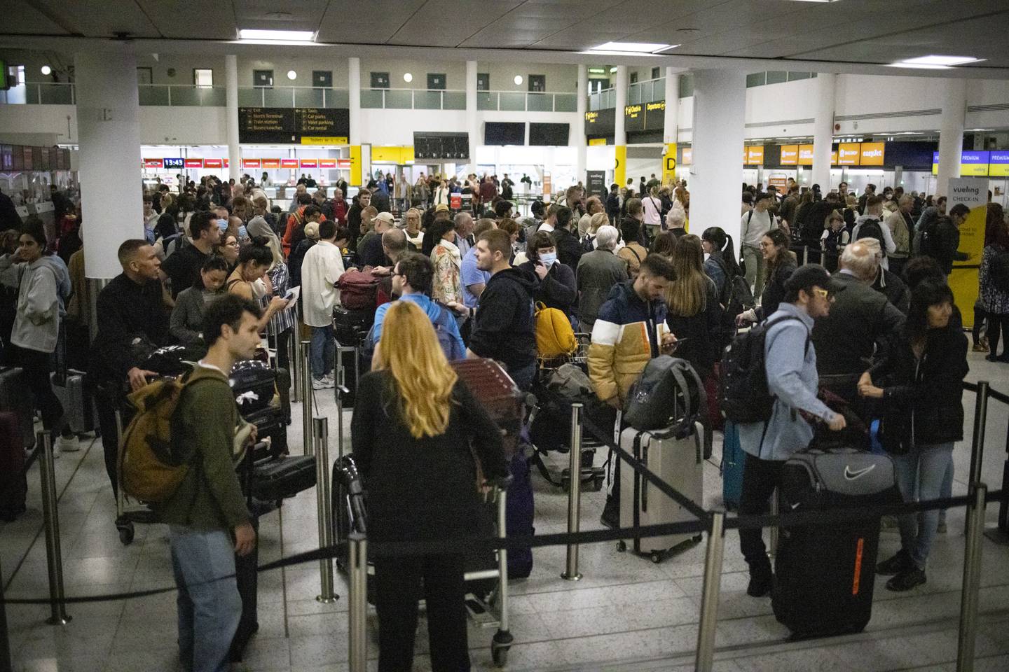 Passengers queue at Gatwick Airport on Tuesday amid flight cancellations and longer-than-usual waiting times. EPA 