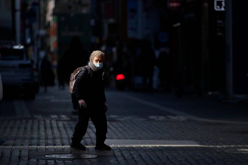 A woman wearing a face mask as a precaution against the coronavirus, walks in downtown Seoul, South Korea, Wednesday, Jan. 27, 2021. (AP Photo/Lee Jin-man)