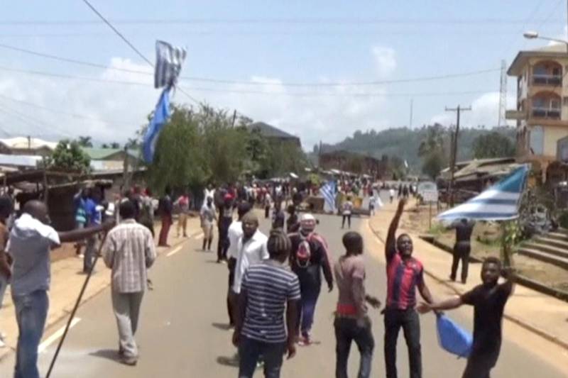 A still image taken from a video shot on October 1, 2017, shows protesters waving Ambazonian flags as they walk along a street in the English-speaking city of Bamenda, Cameroon. REUTERS/via Reuters TV