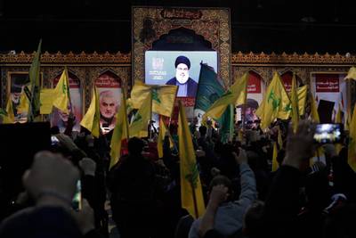 Hezbollah supporters wave the group's flag as they listen to Hassan Nasrallah speak. AP Photo