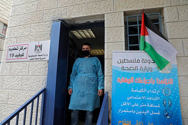 A Palestinian health worker stands at the entrance of a Covid-19 vaccination centre in the West Bank city of Nablus. AFP