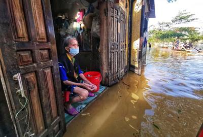 A woman sits at her flooded house in Quang Binh province, Vietnam. Reuters