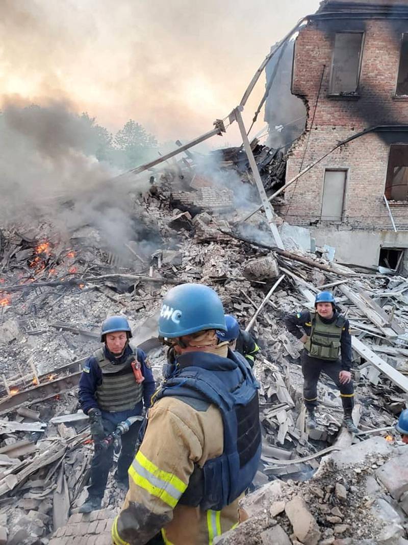Emergency personnel at a school building hit by shelling, in the village of Bilohorivka, Luhansk. Reuters