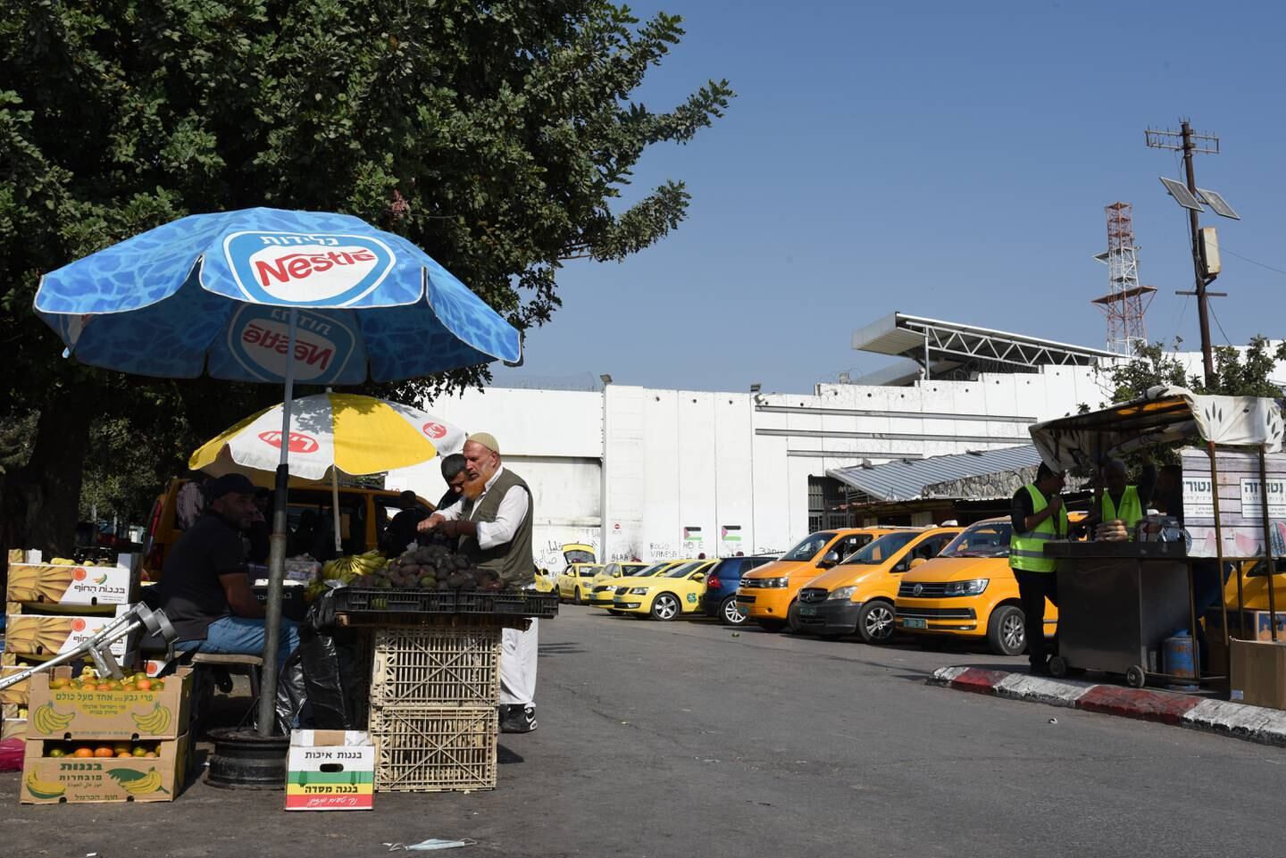 A man buys food outside Bethlehem's Checkpoint 300, a pedestrian crossing built by Israel. Rosie Scammell / The National