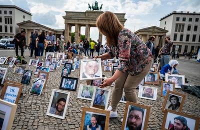Pictures of Syrians who have been detained or forcibly disappeared are placed on the pavement during a demonstration in Berlin. AFP